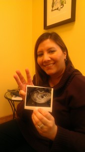 Julie holding up three fingers and an ultrasound photo